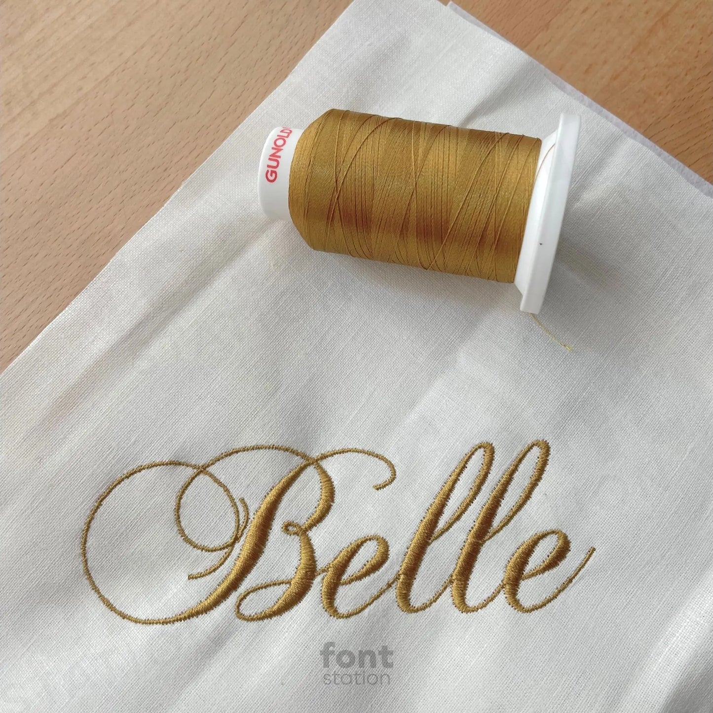 Image showing a word embroidered on textile using the Champagne embroidery font created by FontStation