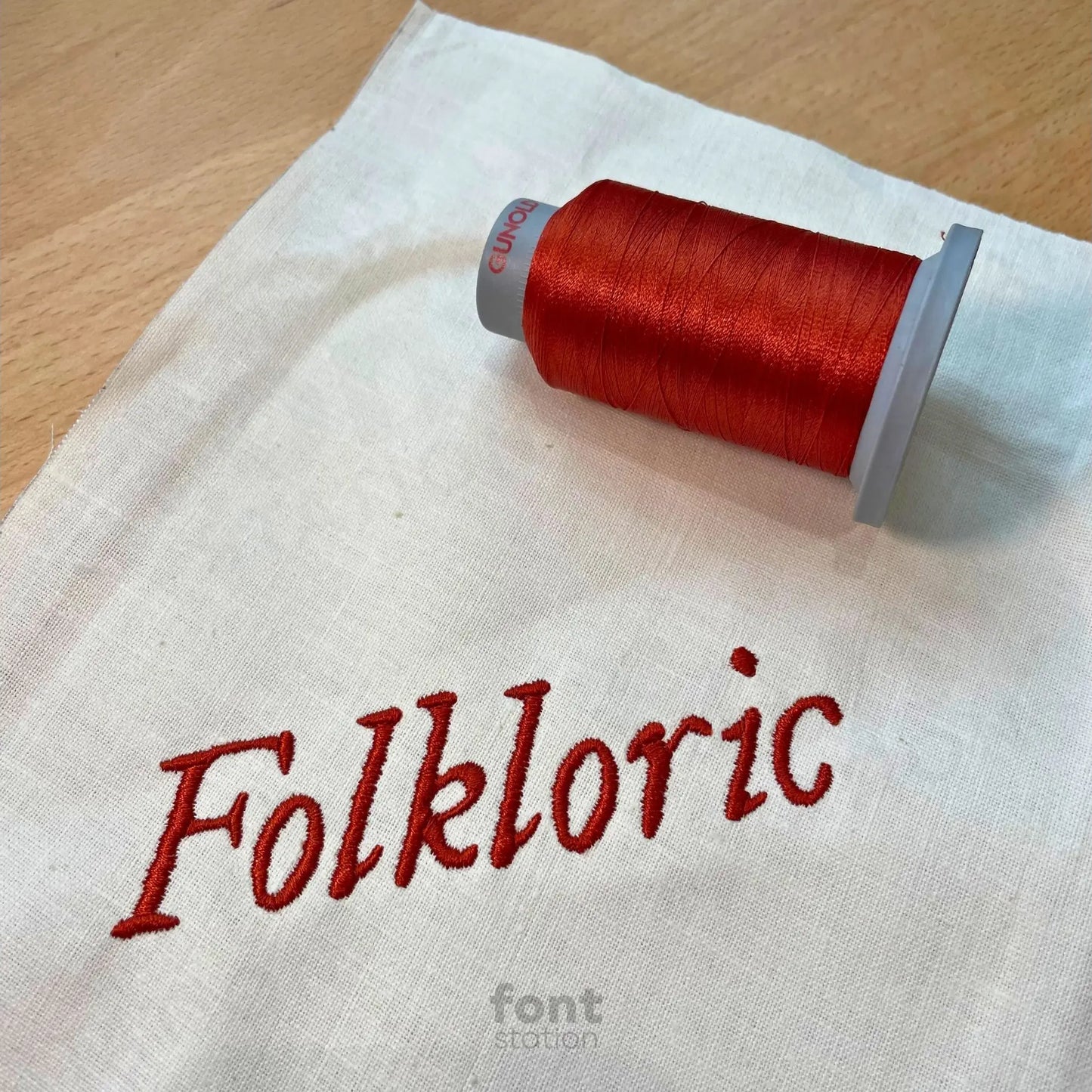Image showing a word embroidered on textile using the Folkloric embroidery font created by FontStation