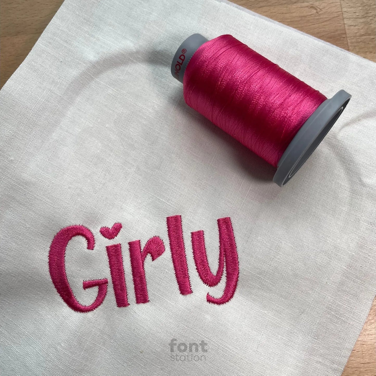 Image showing a word embroidered on textile using the Girly embroidery font created by FontStation