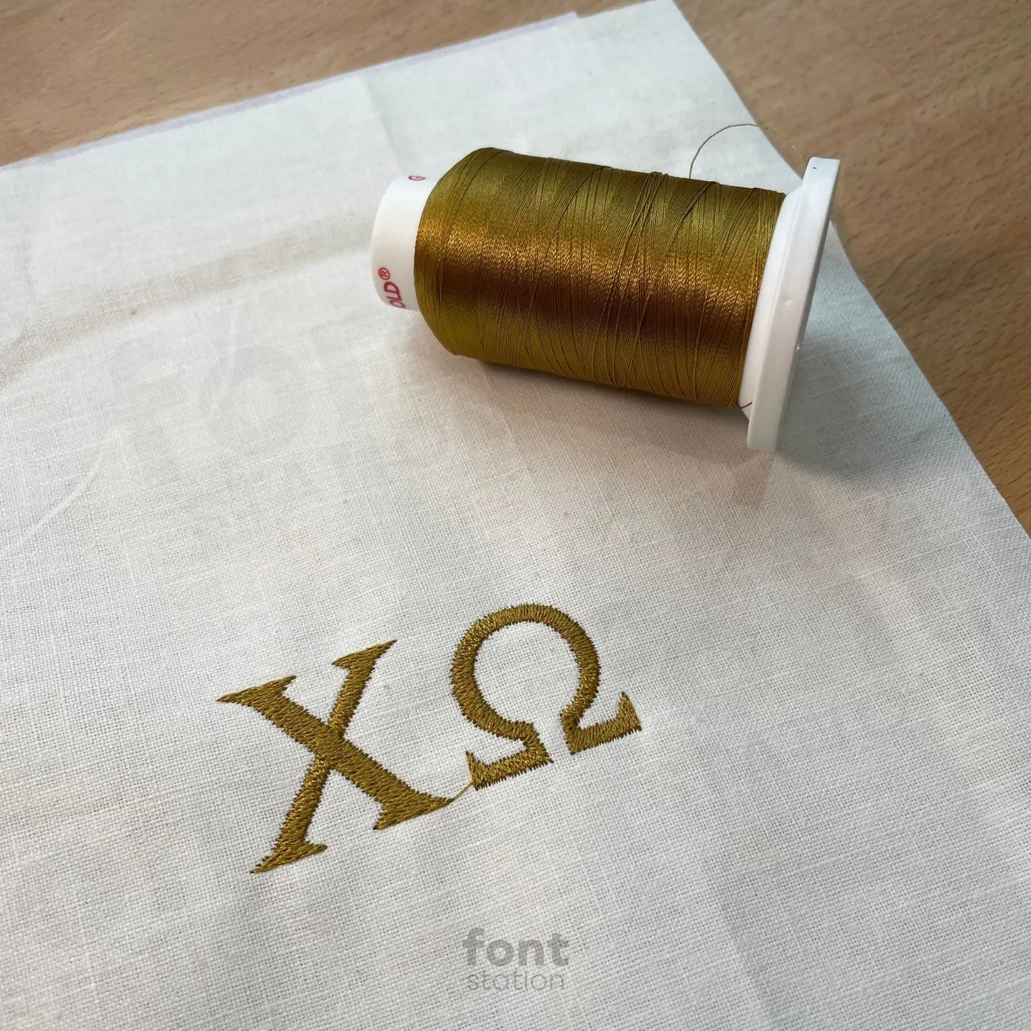 Image showing a word embroidered on textile using the Greek Letters embroidery font created by FontStation