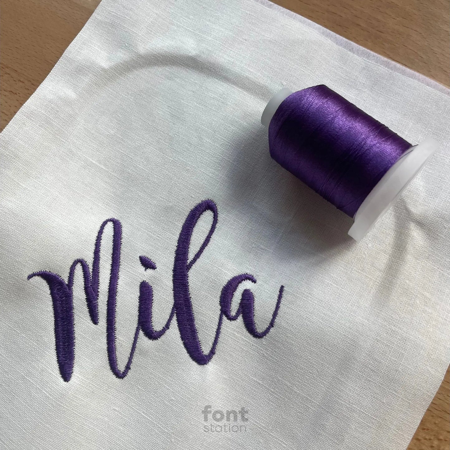 Image showing a word embroidered on textile using the Magnolia Sky embroidery font created by FontStation