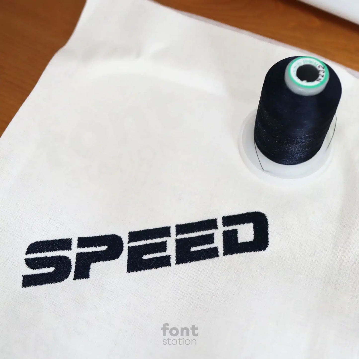 Image showing a word embroidered on textile using the Racing embroidery font created by FontStation