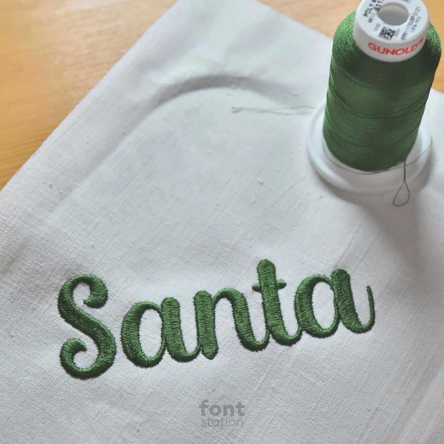Image showing a word embroidered on textile using the Santa Claus embroidery font created by FontStation