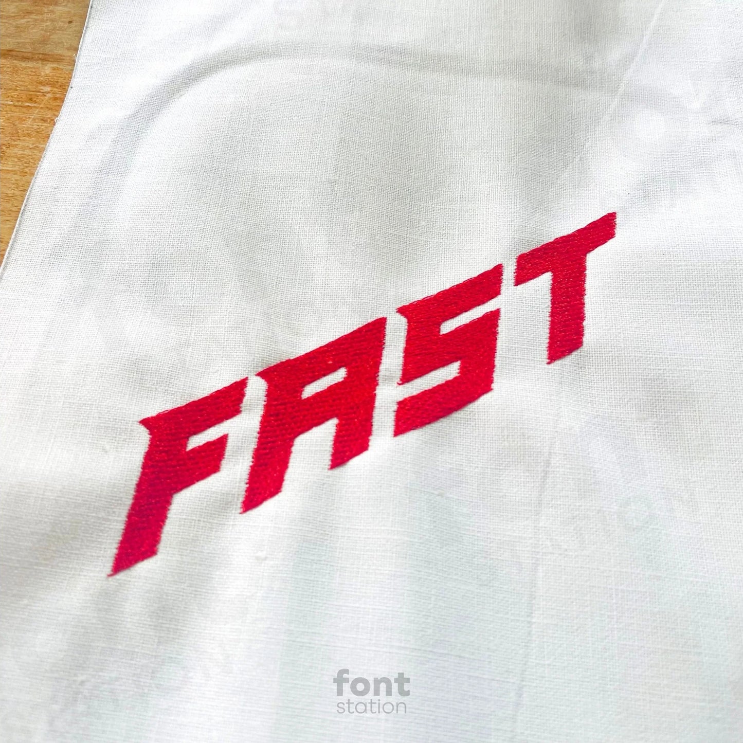 Image showing a word embroidered on textile using the Speed embroidery font created by FontStation