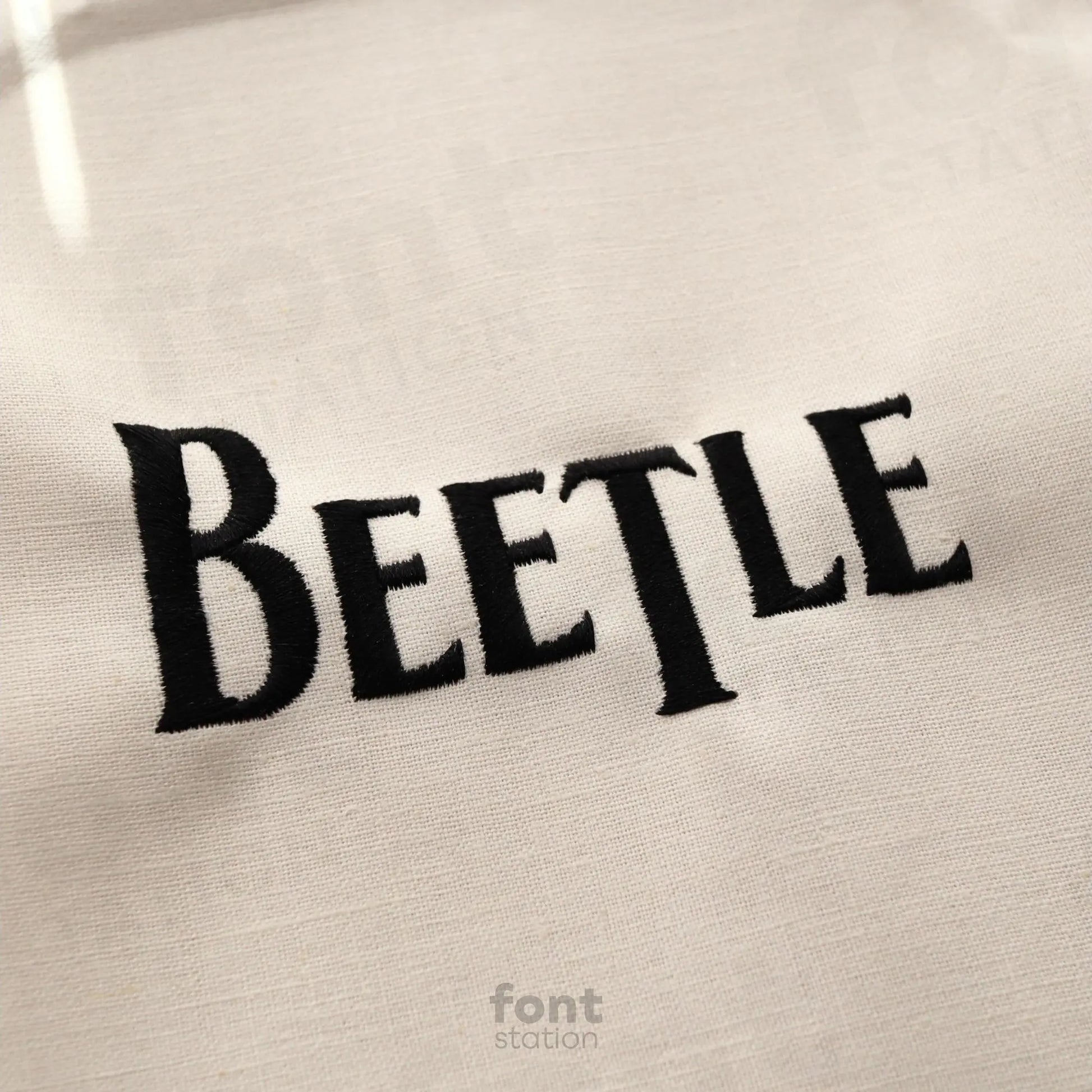 Image showing a word embroidered on textile using the Beatles embroidery font created by FontStation