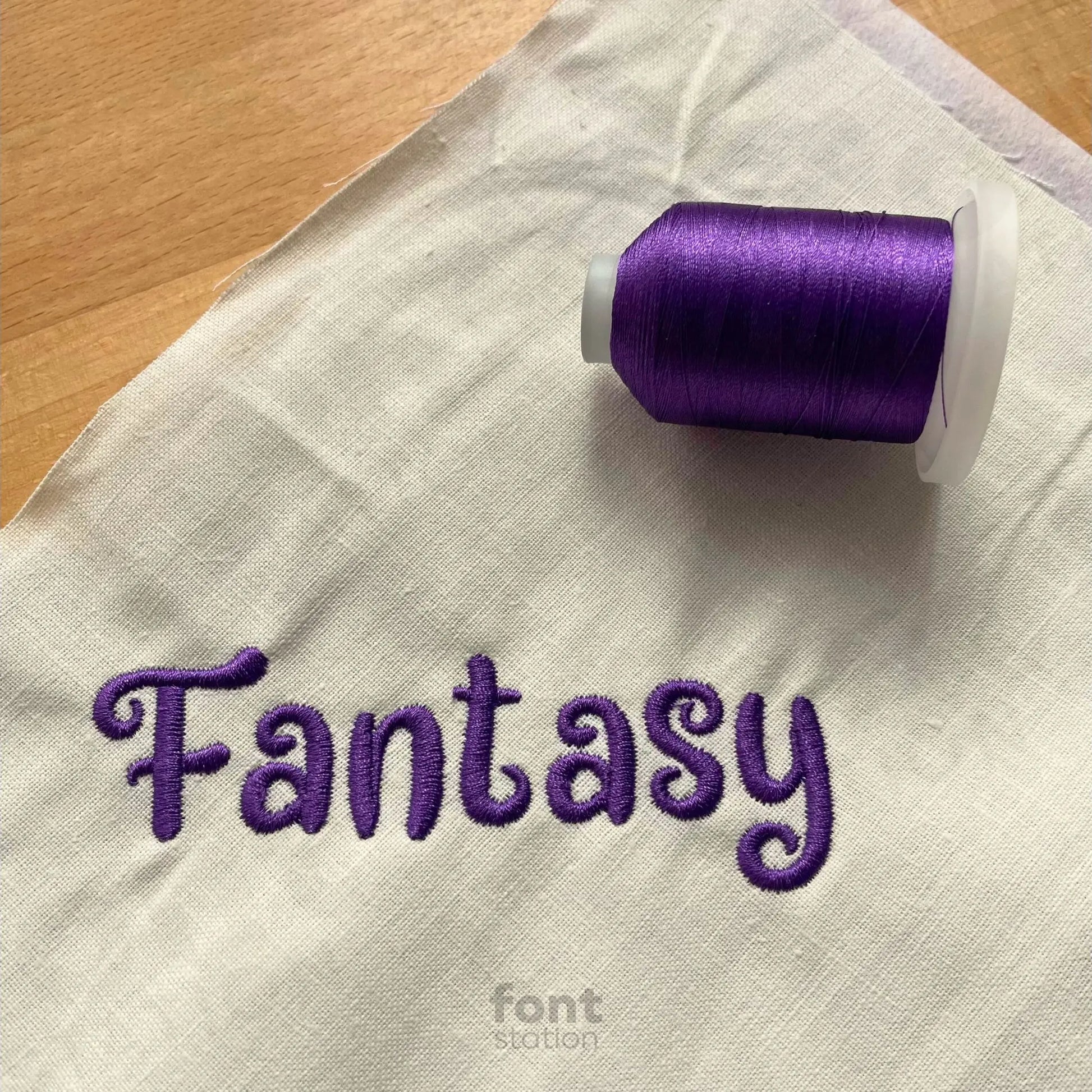 Image showing a word embroidered on textile using the Fantasy embroidery font created by FontStation