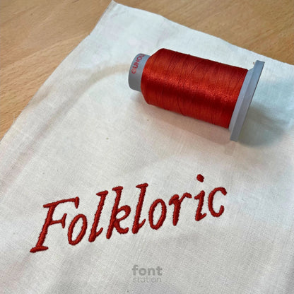 Image showing a word embroidered on textile using the Folkloric embroidery font created by FontStation