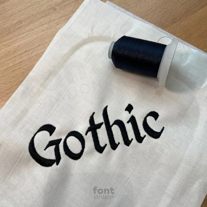 Image showing a word embroidered on textile using the Gothic embroidery font created by FontStation