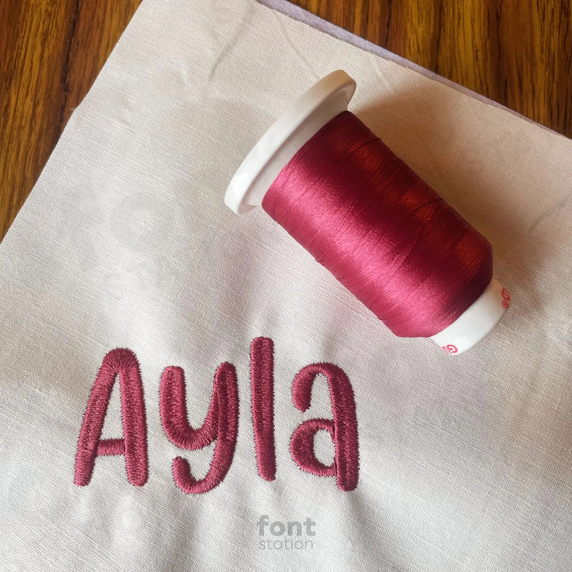 Image showing a word embroidered on textile using the Unicorn embroidery font created by FontStation