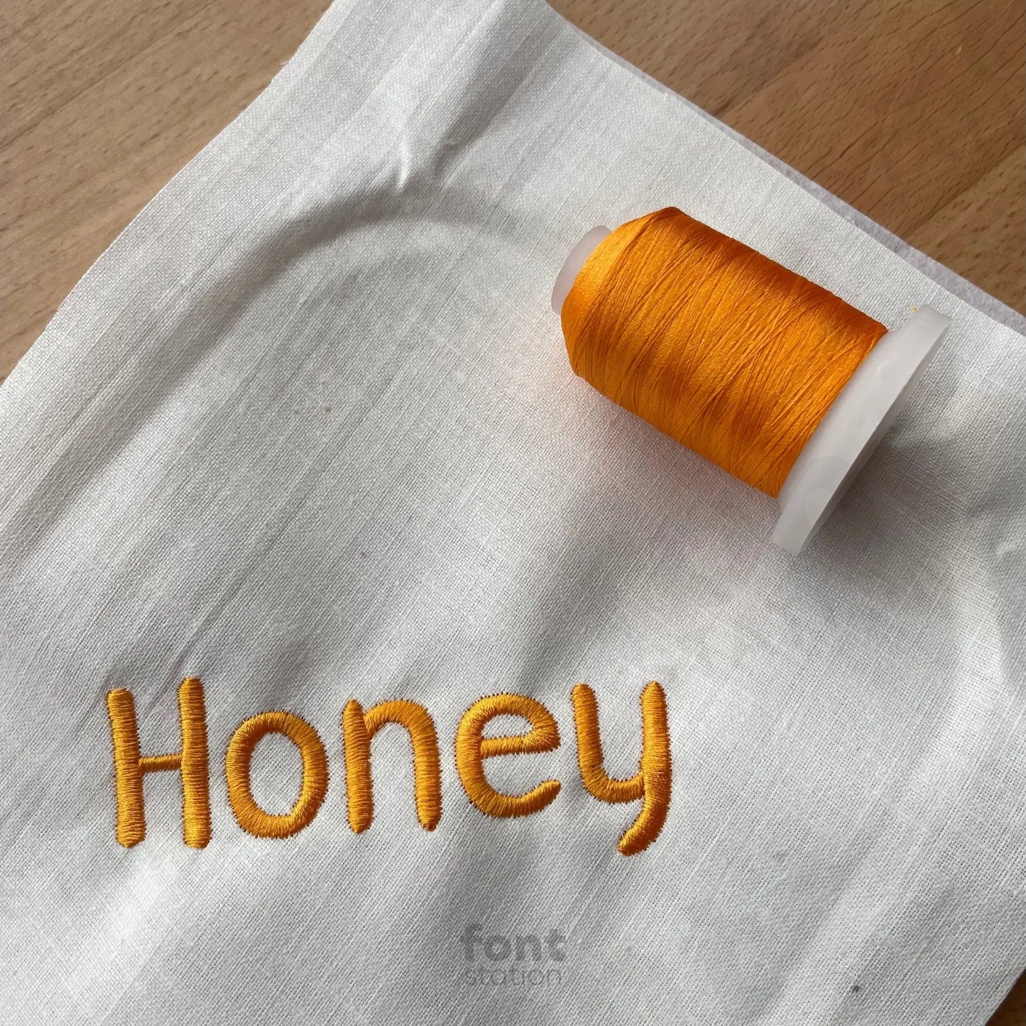 Image showing a word embroidered on textile using the Winnie embroidery font created by FontStation